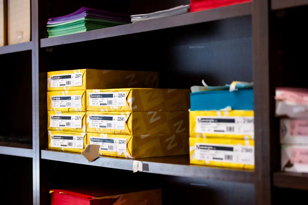 Cutii de arhivă galbene pe rafturile unui birou, pentru păstrarea pe termen lung a documentelor contabile