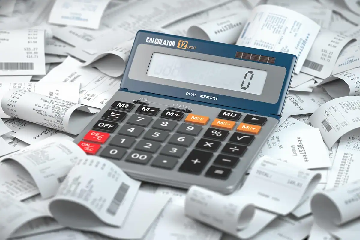 Calculator de birou pe un morman de bonuri fiscale ce așteaptă decontarea cheltuielilor