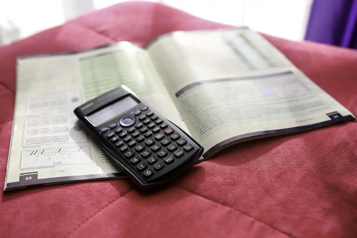 Registru contabil deschis și calculator științific pe masă, pentru ținerea corectă a contabilității firmei