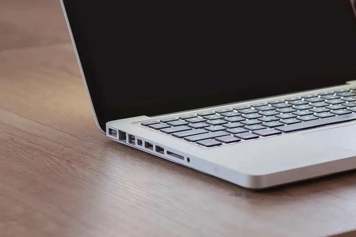 Laptop deschis pe un birou din lemn, pregătit pentru depunerea online a declarației de profit
