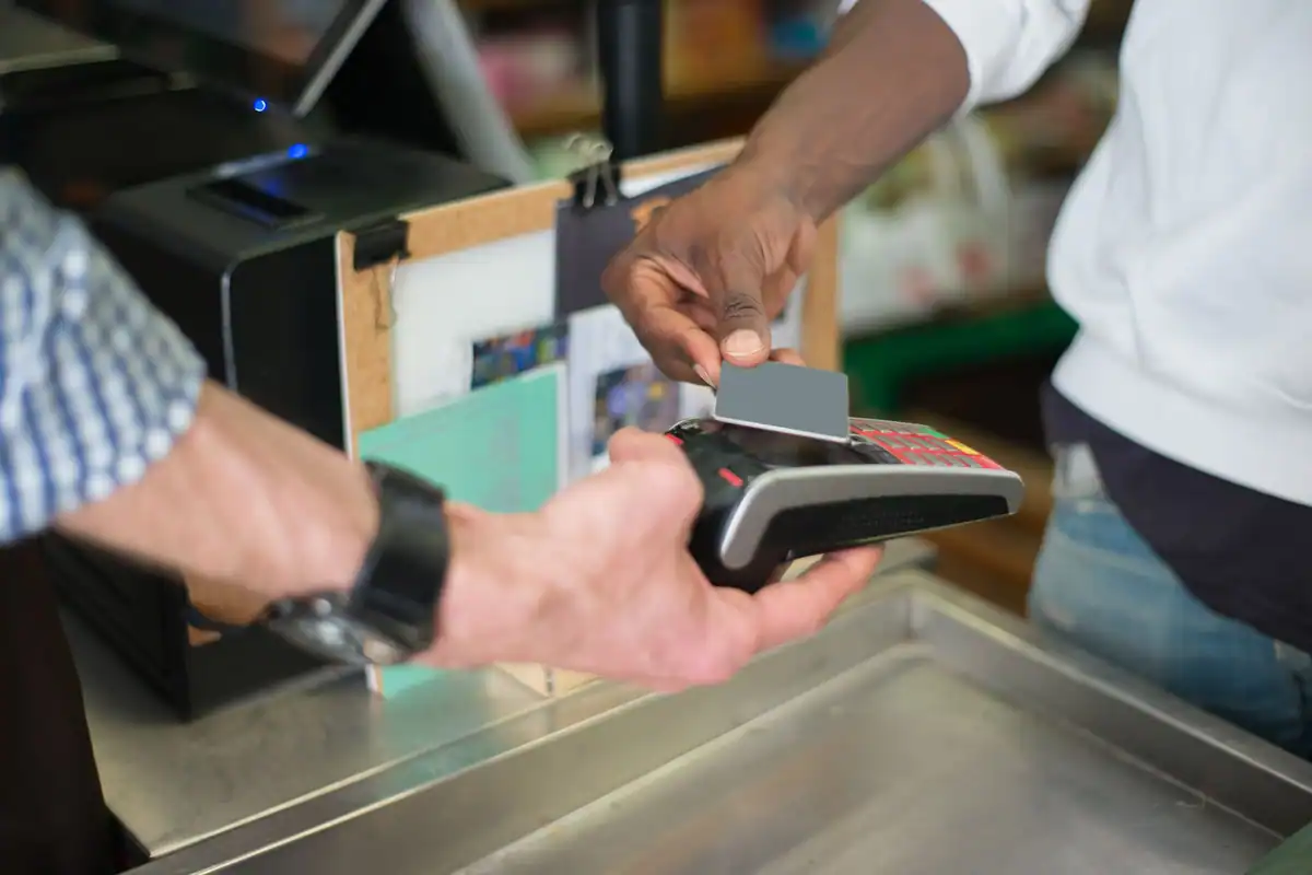 Client care plătește cu cardul la un terminal contactless, într-un magazin, în sistemul TVA la încasare